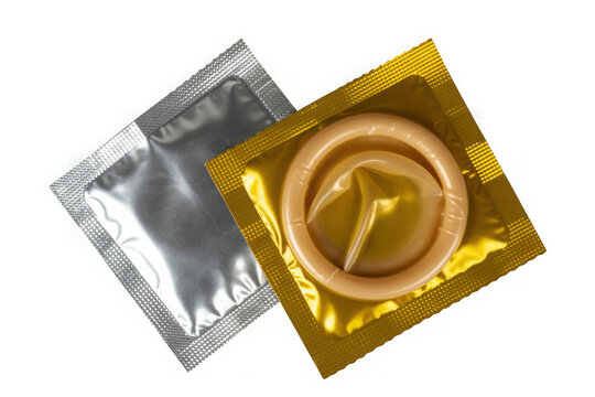 Two opened condom packages one silver one gold showing a rolled condom on black