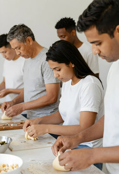 Diverse group of people preparing dough for baking, cooking class and culinary education, Family activity and bonding