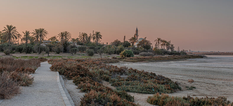 The famous Hala Sultan Tekke, as seen at sunset, also known as the Mosque of Umm Haram, is one of the most significant Islamic monuments in the world, located on the west bank of Larnaca, Cyprus