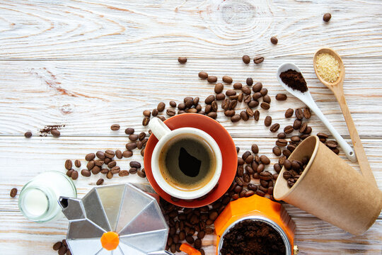 Coffee Concept Flat Lay with Geyser Coffee Maker, Cup, Milk and Beans, ground coffee on spoons, and roasted coffee beans Background