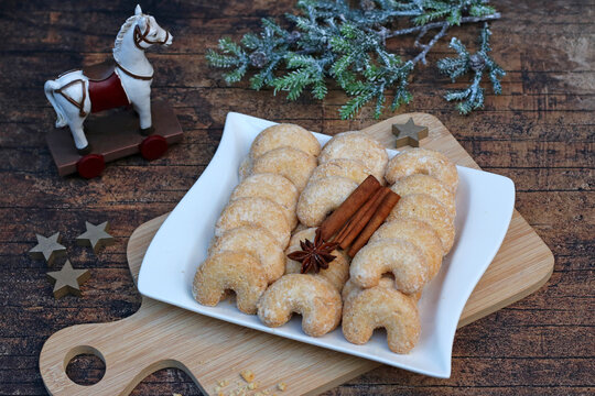Vanillekipferl traditionelles Weihnachtsgeb&auml;ck auf einem Holztisch mit Sternanis und Zimtstangen.