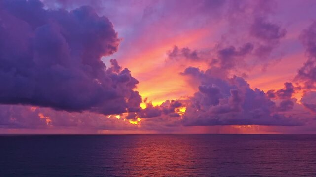 Scenic coastal landscape capturing waves rolling onto a sandy beach under a glowing sunset sky. The rich colors and dynamic cloud formations create a powerful yet calming ocean atmosphere