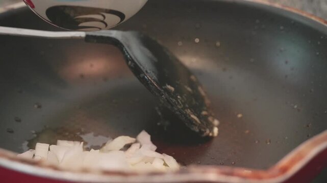 A close-up view of a frying pan with chopped onions showcasing the cooking process and vibrant colors.
