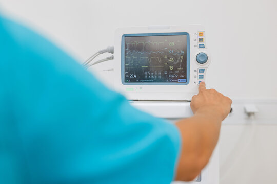 A medical staff member checks the vital signs of a patient in a hospital. The operation is ongoing, and monitoring is critical.