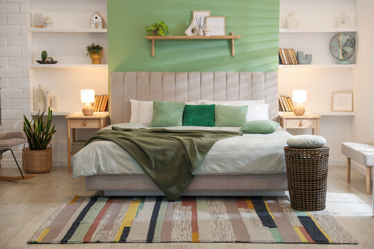 Comfortable large bed, other furniture and decor in bedroom. Interior design