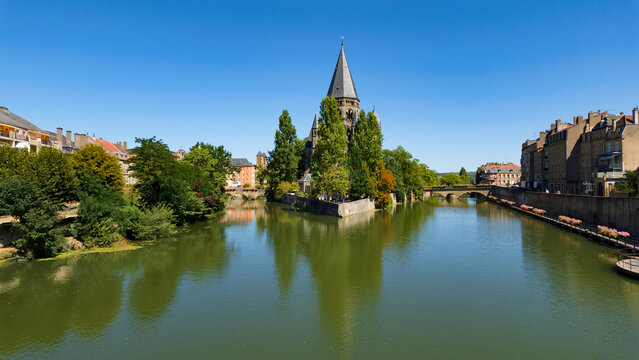 Temple Neuf standing on an island in the Moselle River with its reflection