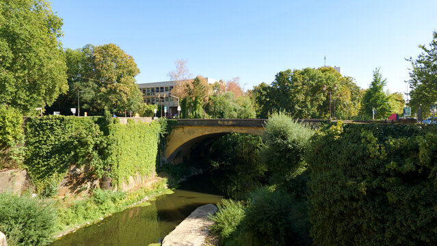 River Moselle flowing under an old stone bridge in Metz, France