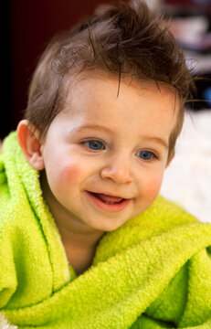 Cute boy in green bathrobe. Shot from above. Looking away from the camera