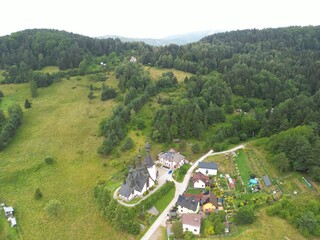 Krynica-Zdrój - Polska Panorama miasta i okolicznych gór nagrana dronem. Jaworzyna Krynicka, Góra Parkowa, miasto, Beskidy, lasy, mgła i chmury nisko osadzone opadające na góry © Konrad