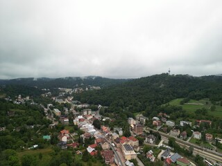 Krynica-Zdrój - Polska Panorama miasta i okolicznych gór nagrana dronem. Jaworzyna Krynicka, Góra Parkowa, miasto, Beskidy, lasy, mgła i chmury nisko osadzone opadające na góry © Konrad