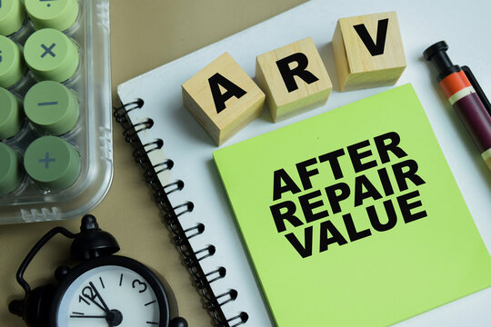 Concept of ARV - After Repair Value write on sticky notes isolated on Wooden Table.