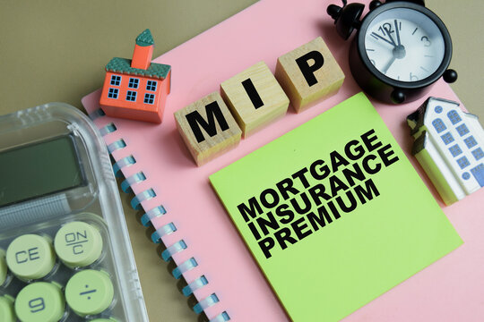 Concept of MIP - Mortgage Insurance Premium write on sticky notes isolated on Wooden Table.