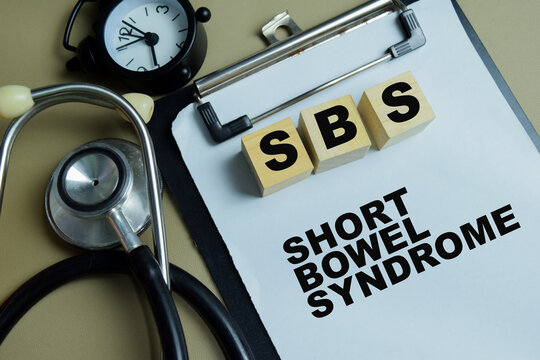 Concept of SBS - Short Bowel Syndrome write on clipboard isolated on Wooden Table.