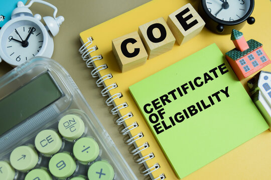 Concept of COE - Certificate Of Eligibility write on sticky notes isolated on Wooden Table.
