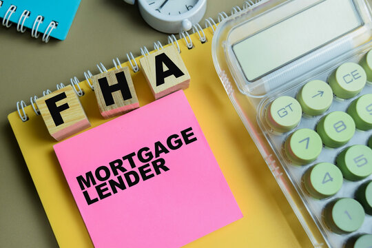 Concept of FHA - Mortgage Lender write on sticky notes isolated on Wooden Table.