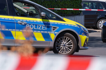 German police car behind cordon tape at a secured residential scene © Aleksandr Fedosov