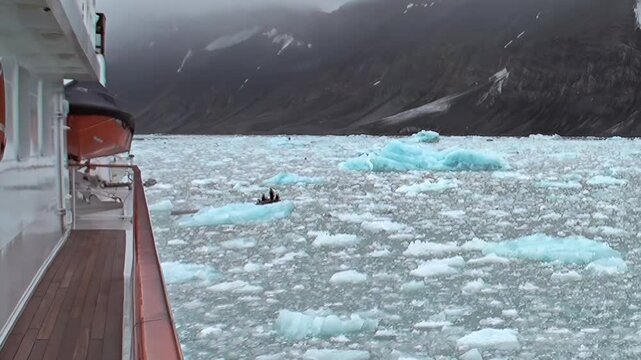 Witness serene beauty of Arctic Ocean. From ship's deck, observe countless ice floes and towering mountains, as graceful seals find peaceful repose on floating ice amidst cool, crisp air.