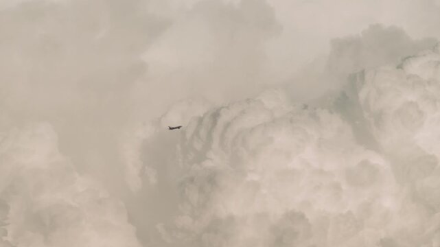 Tokyo,Japan -August 14, 2026: A climbing airplane bypassing cumulonimbus clouds