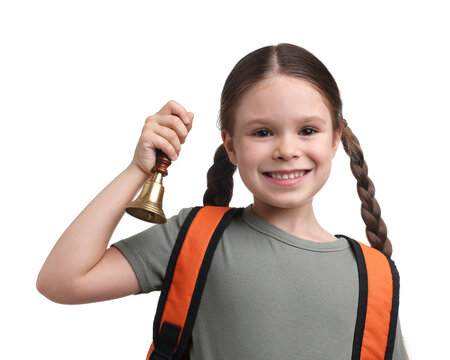 Smiling little girl with backpack ringing school bell on white background