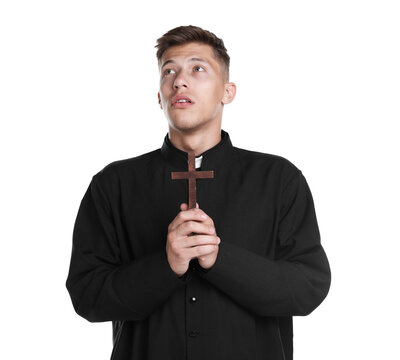 Young priest with wooden cross on white background