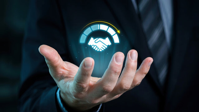 Businessman holding a glowing holographic handshake icon representing business success and partnership connection concept