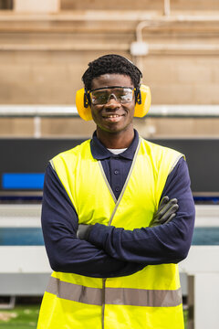 African worker wearing safety gear in lumberyard