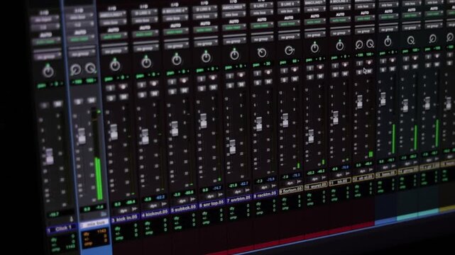 Vista en pantalla de mezclador de audio digital DAW con v&uacute;metros en movimiento y canales de audio en estudio.