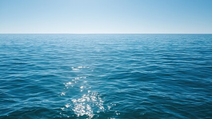 Naklejka premium Calm blue sea surface background with gentle ripples and sun reflections