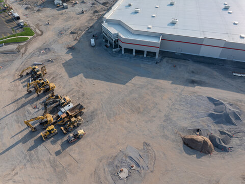 Buffalo, New York, United States - 19 July 2026: Aerial view of a construction site near a Costco warehouse featuring heavy machinery, excavators, and piles of gravel.