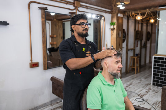 Barbershop employee styling client's hair