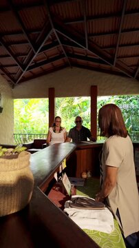 Tourist couple checking in at tropical resort reception desk