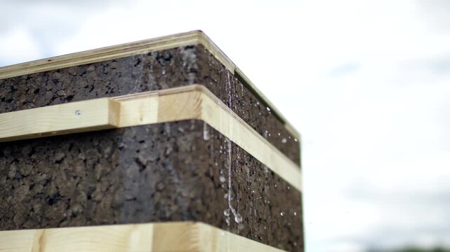 Close up of cork clad building corner with water running down surface