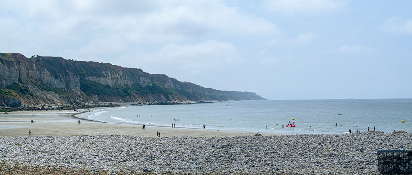 Vista panor&aacute;mica de la Playa de Saint-Jouin-Bruneval de cantos rodados, al fondo acantilados sobre un cielo nuboso y mar gris en la costa de la Normand&iacute;a francesa, viajando en verano 2022
