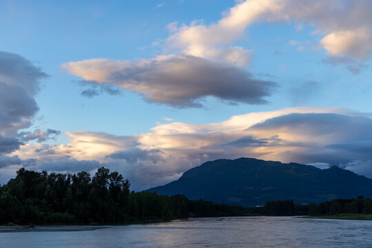 Dramatic Sunset Clouds Over Mountain River and Forest Landscape Near Chilliwack, BC Canada