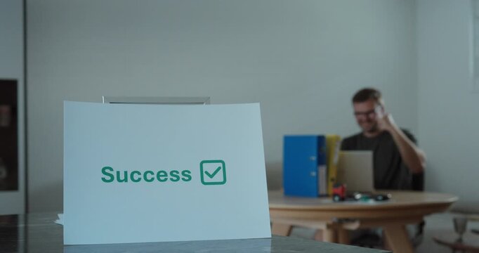 Businessman celebrating success while working on a laptop in a home office. Ideal for business success, productivity, entrepreneurship, and remote work concepts.