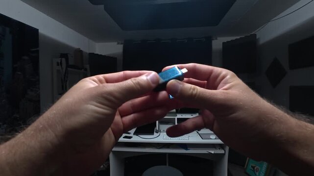 First-person POV holding and inspecting a USB flash drive. Ideal for data storage, file transfer, backup, and technology concepts.