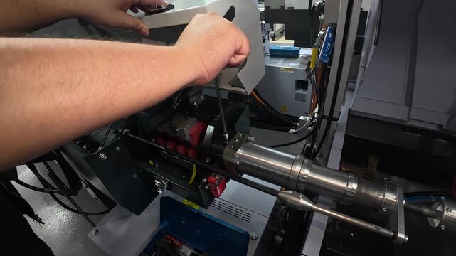 A technician performs maintenance and service work on an industrial machine to ensure reliable operation and prevent equipment failures. Concept of preventive maintenance, manufacturing, and industria