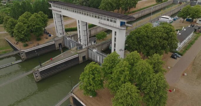 Drone approaches a sluice gate closely as an inland tanker barge waits in the lock chamber for the gate to open and continue its journey along the canal.