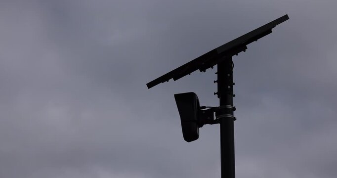 Fullerton, California, USA - August 14, 2026: An AI Flock camera surveils a city street for car license plates on a dark cloudy day.