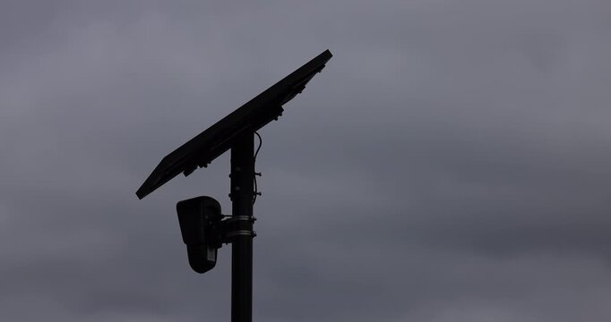 Fullerton, California, USA - August 14, 2026: An AI Flock camera surveils a city street for car license plates on a dark cloudy day.