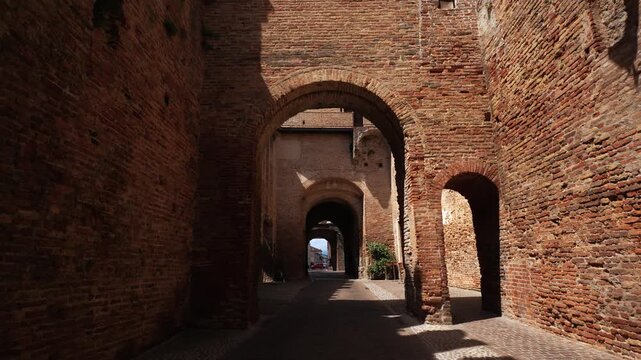 POV walkthrough walking through the massive stone archway of the historic city gate into Cittadella.