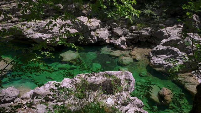 Vibrant green natural pool in Meduna river canyon. Scenic limestone rock formations, Friuli, Italy