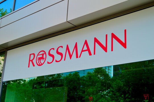 Rossmann drugstore retail chain exterior facade with bold red logo sign on modern white building storefront in urban city setting