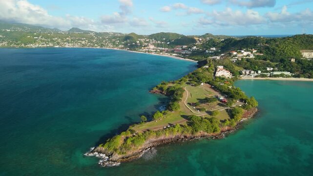 Aerial parallax around Quarantine Point peninsula with Grand Anse Bay and coastal town in the background, Grenada