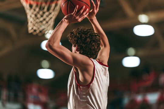 Curly-haired Basketball Player in Action, Hoop in Background