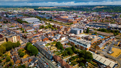 Fototapeta premium Wide drone perspective of Burton townscape with industrial breweries and railway line