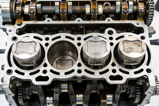 Engine block cut open showing pistons at different heights in bores