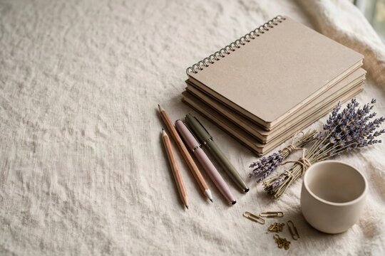 Stationery flat lay with journals, pens, and dried lavender