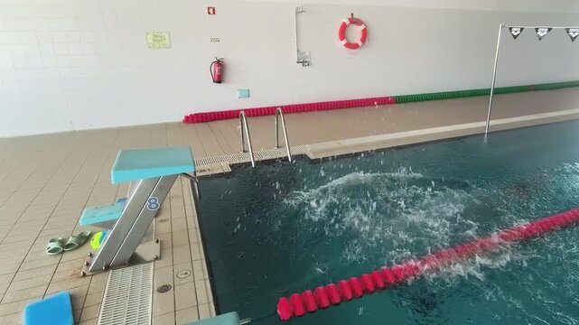 Adult woman practices diving technique from the pool edge, learning proper body position, correcting beginner mistakes, building confidence, coordination, and swimming skills safely