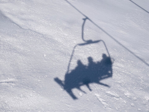 Silhouette d'une t&eacute;l&eacute;cabine de ski se refl&eacute;tant sur la neige immacul&eacute;e, sc&egrave;ne hivernale abstraite captur&eacute;e sous un angle original et cr&eacute;atif